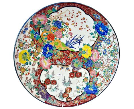 A large 19th century Japanese charger with highly ornate polychromatic floral enamel design, bearing an indistinct inscriptio