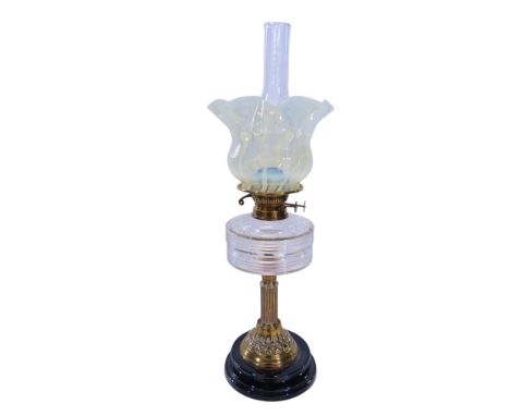 A brass column oil lamp with a clear font and vaseline flared shade. 62cm high approx. 