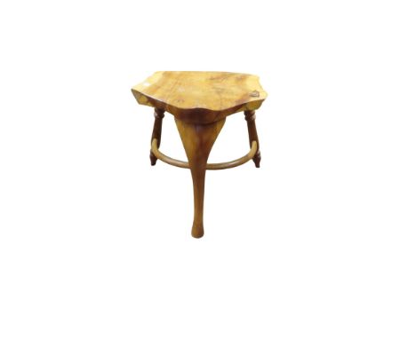 A yew wood stool with saddle seat on three turned supports, with crinoline stretcher, stamped Peter Tree (the chairman of Rau