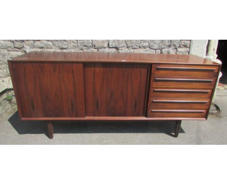 A Danish rosewood sideboard by H P Hensen with twin sliding doors and a row of five end drawers raised on square tapered supp