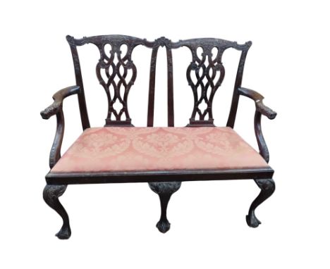 A Georgian mahogany two seat sofa with carved pierced splats, raised on shaped supports, with claw and ball feet, 115cm wide