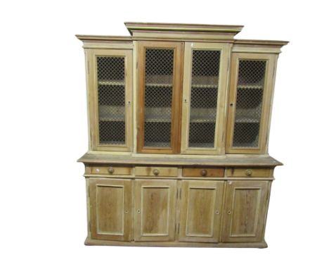 A large reclaimed pale pine breakfront dresser with strap work panelled doors over an arrangement of four drawers and hinged 