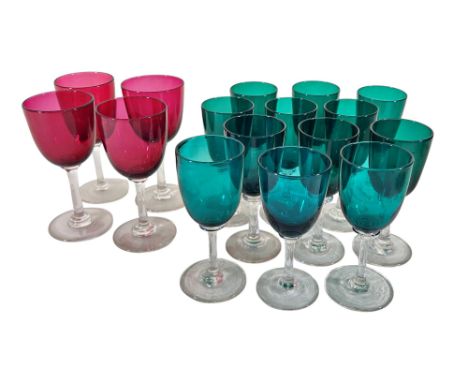 Four red wine glass and twelve near matching green wine glasses. 