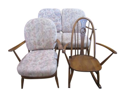 An Ercol Windsor style two seat stickback sofa with loose cushions, matching armchair and a further Windsor rocking chair wit