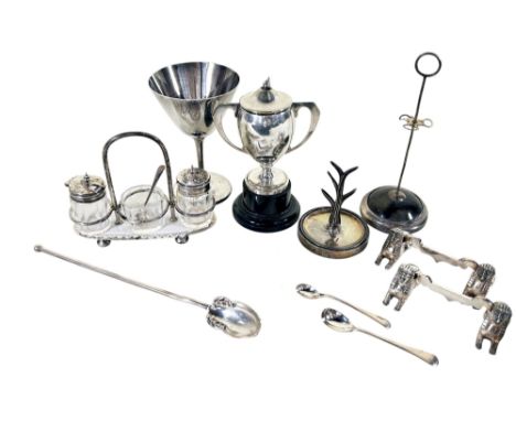 A mixed selection of silver to include a trophy, a wine goblet, a cruet set on stand. a long spoon, a ring stand, various mus