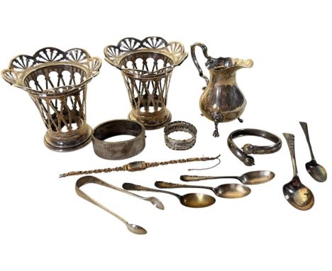 A mixed collection of silver items to include vase covers, cream jug, teaspoons, bangles, napkin ring and a sugar tong, 14oz