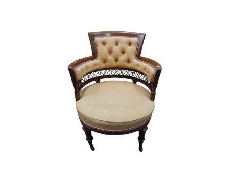 An Edwardian mahogany drawing room chair with horseshoe shaped back and fret work frieze upholstered in apricot coloured mate