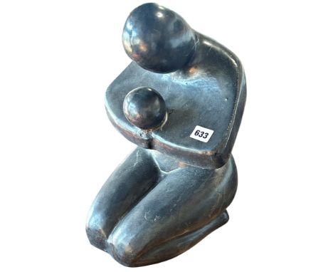 A glazed terracotta abstract study of a woman clasping a child, 40cm high.