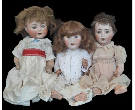 Three early 20th century bisque head character dolls comprising a Burggrub Baby (probably by Schoenau &amp; Hoffmeister with 