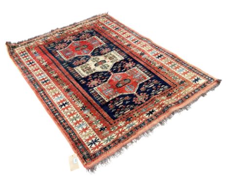 A Persian rug with triple medallion centre on a blur ground 175cm x 129cm 