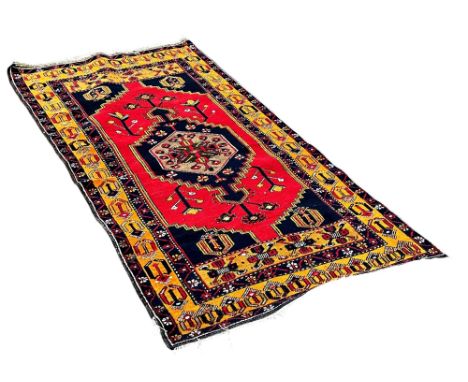 A Persian design rug with an extended stepped medallion on a red ground and mustard border 200cm x 105cm 