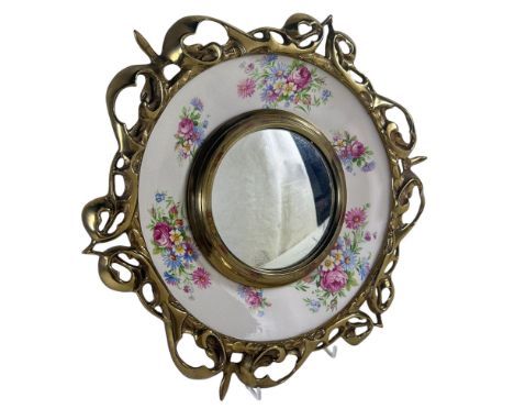 A Clarice Cliff ceramic plate with floral bands enclosing a convex mirror within a decorative brass border 