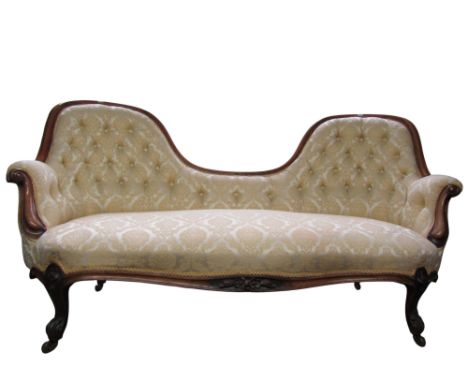 A Victorian upholstered two-seat conversation sofa, raised on carved legs and casters