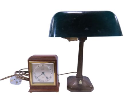 An early 20th century bankers desk lamp with a green glass adjustable shade, together with a working wind up Elliott of Londo