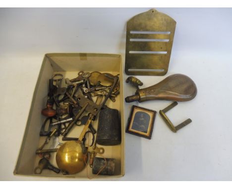 A box of assorted metalware including a brass shot flask, clock winders etc.