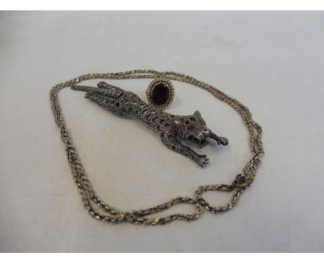 A silver (marked 925) brooch in the form of a recumbant cheetah with moving tail inset with stones to the tail and head, a 19