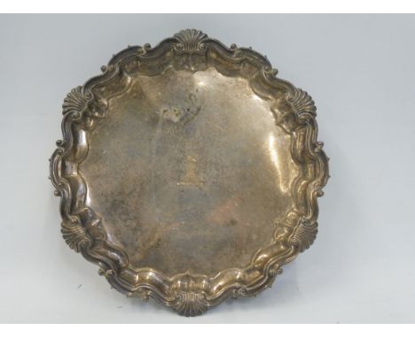 A silver waiter with scrolled border on ball and claw feet, bearing a central armorial, maker Martin Hall &amp; Co. Ltd, Shef