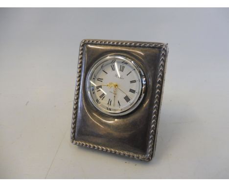 A small contemporary silver cased table clock. 