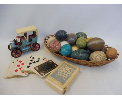 A Japanese Modern Toys tinplate model of a veteran car with friction operated sound effect, plus a set of playing cards adver