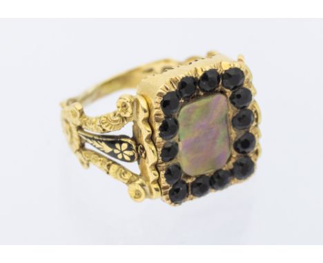 A Georgian 18ct gold pearl set mourning swivel top ring, one side with half pearls, the centre with later replacement mother 