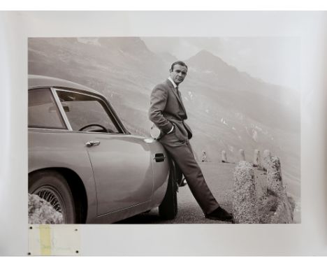 Sean Connery - An early signed autograph on card with a large photographic print of Sean Connery as James Bond with an Aston 