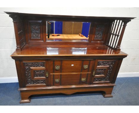 AN EARLY 20TH CENTURY WALNUT MIRROR BACK SIDEBOARD, the raised back with a central bevelled mirror plate, flanked by carved p