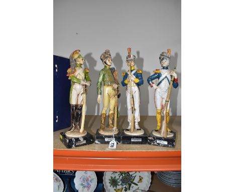 A GROUP OF FOUR ITALIAN-MADE COMPOSITE NAPOLEONIC FIGURES in period costume, mounted on square Carrara marble bases, approxim