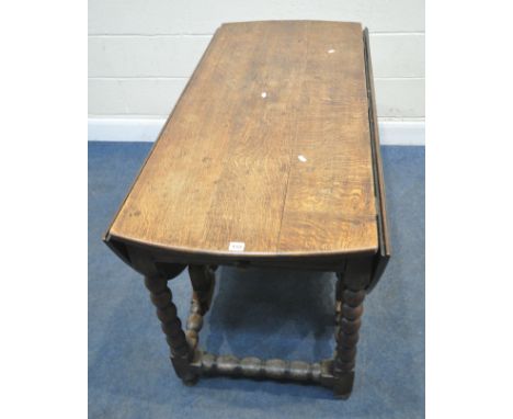A GEORGIAN OAK GATE LEG TABLE, with a single drawer to each end, raised on bobbin turned legs, united by stretchers, open len