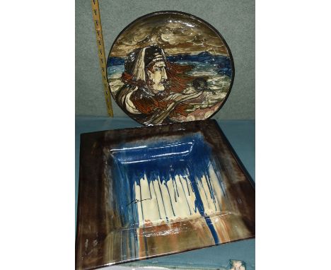 A STUDIO POTTERY CHARGER AND SQUARE DISH, the charger with painted sgraffito decoration depicting a woman in a stormy lakesid