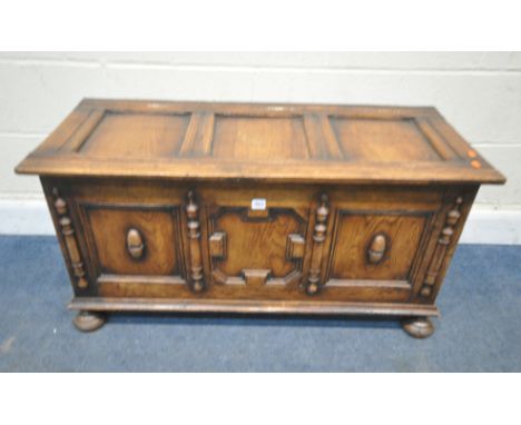 AN EARLY 20TH CENTURY OAK BLANKET CHEST, with geometric panels, raised on bun feet, width 106cm x depth 47cm x height 53cm, a