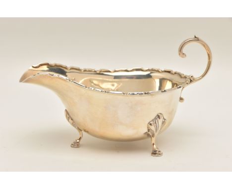 A GEORGE VI SILVER SAUCE BOAT, polished form with wavy rim, scrolling handle and raised on three hoof feet, hallmarked 'Adie 