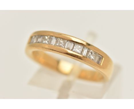 AN 18CT GOLD DIAMOND HALF ETERNITY RING, set with a row of alternating princess cut and rectangular cut diamonds, channel set