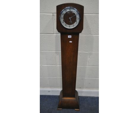 AN ART DECO OAK GRANDDAUGHTER CLOCK, with an arched hood, the convex glass door enclosing a 7 inch dial depicting Arabic nume