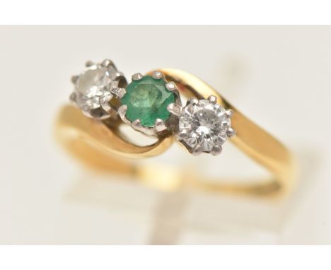 AN 18CT GOLD EMERALD AND DIAMOND THREE STONE RING, set with a central circular cut emerald, flanked with two round brilliant 