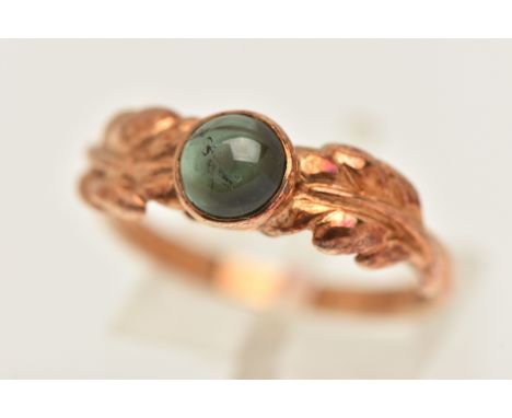 A 9CT GOLD GEM SET RING, a round cabochon tourmaline, collect set in yellow gold with foliage detail to the shoulders, hallma