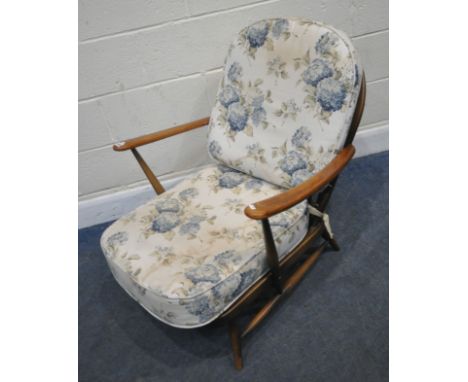 LUCIAN ERCOLANI, A MID-CENTURY ERCOL ELM AND BEECH ARMCHAIR, of deep proportions, the arched backrest with a Fleur De Lis cen