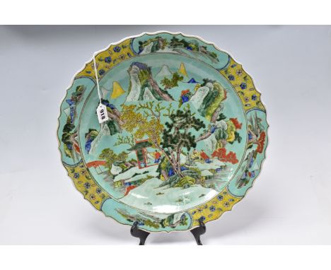 A LARGE CHINESE PORCELAIN CHARGER, with double blue circles on the base and six Chinese  character marks, decorated with fami