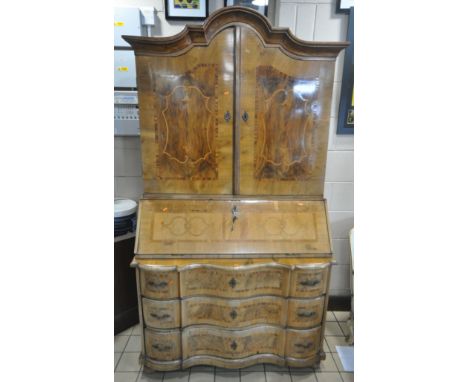 A 19TH CENTURY DUTCH WALNUT BUREAU BOOKCASE, with an arched top, the double doors enclosing nine assorted drawers, and an arr
