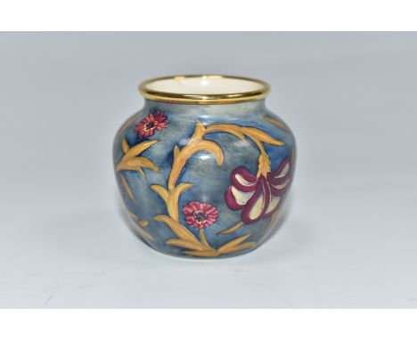 A MOORCROFT ENAMEL MINIATURE BULBOUS VASE, decorated with a floral pattern on a blue ground, with gilt rimmed edge, height 5c