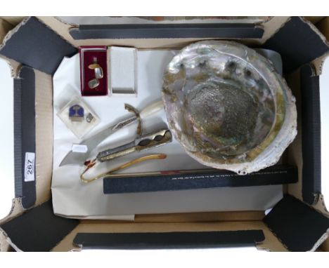 A mixed collection of items to include Abalone Shell, Costume Jewelry, brass nut crackers , pin badges &amp; boxed cufflinks