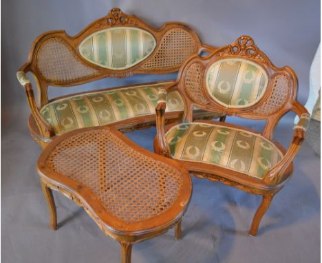 A French Salon Suite comprising of a Sofa with a partly upholstered and caned back above a padded seat with a carved frieze r