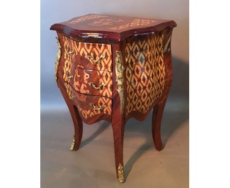 A French Marquetry Inlaid Gilt Metal Mounted Small Serpentine Bombe Commode with three drawers raised upon cabriole legs, 51 