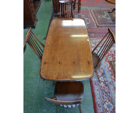 An Ercol dining table and four Ercol spindle back chairs