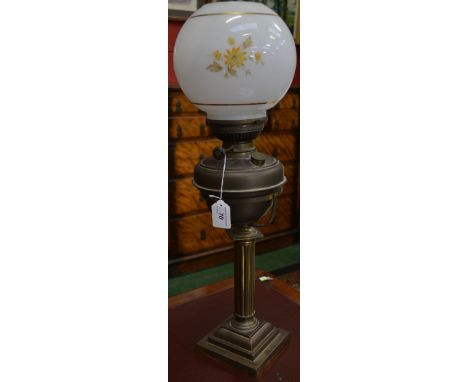 A brass column oil lamp, the reservoir on a gimble, opaque glass shade, Prince and Symmons, London