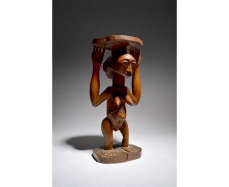 A Luba Hemba caryatid stool Democratic Republic of the Congo the standing female figure with her hands and head supporting th