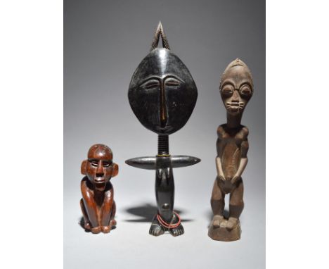 A Baule standing male figure Ivory Coast 32.5cm high, an Ashanti akuaba doll, 40cm high and a carved hardwood crouching figur