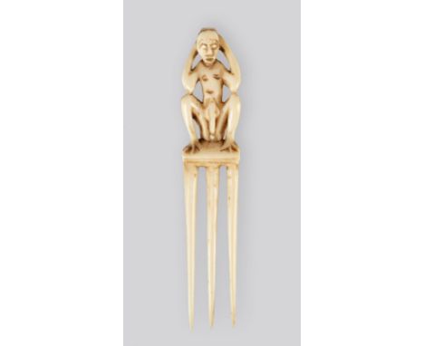 λA Congo comb ivory, with three prongs and a squatting male figure, 1st half 20th century, 10.5cm high.