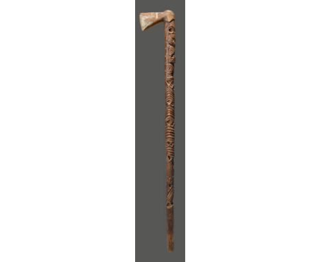 A Maori presentation axe New Zealand with an integral blade and decorated a standing tiki and stylised Janus tiki masks, 88cm