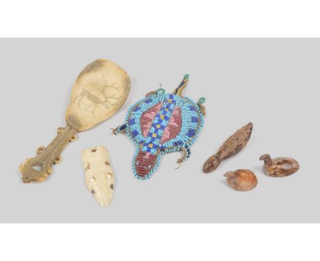 λTwo Inuit gaming pieces Alaska walrus ivory, modelled as birds, 2.8cm and 3.3cm long, an Inuit seal amulet, pierced for atta