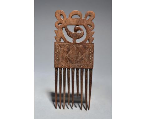 An Ashanti comb Ghana with pierced and carved decoration including a bird, 17.5cm long.